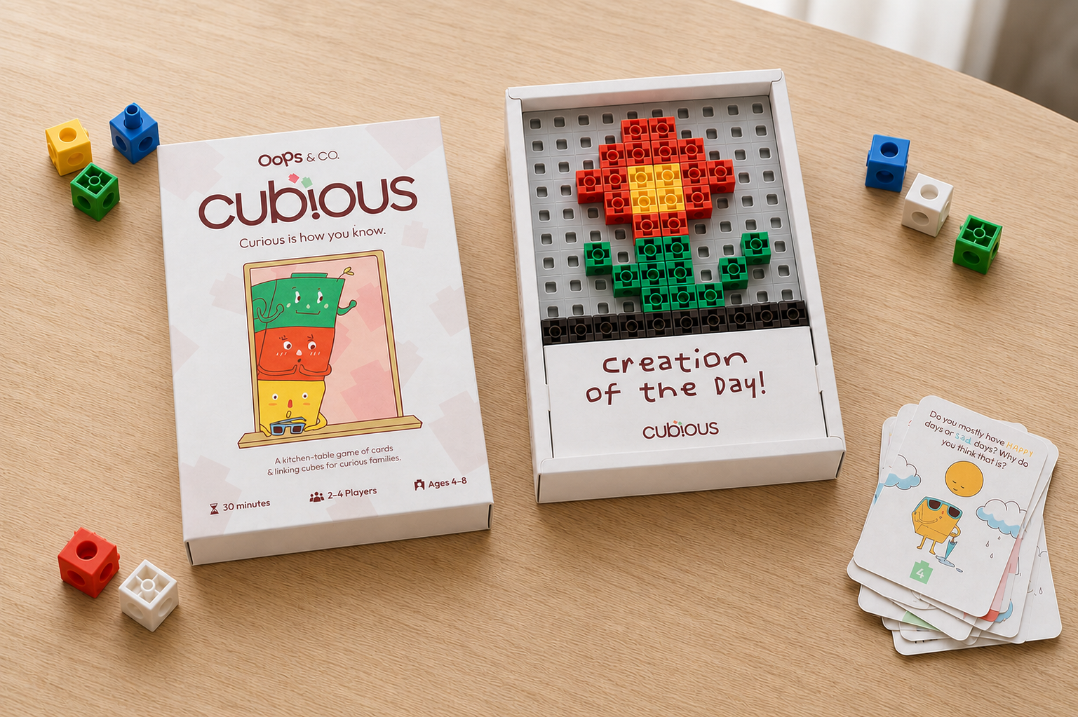 Cubious game box, cards, linking cubes, and a flower built on the baseboard